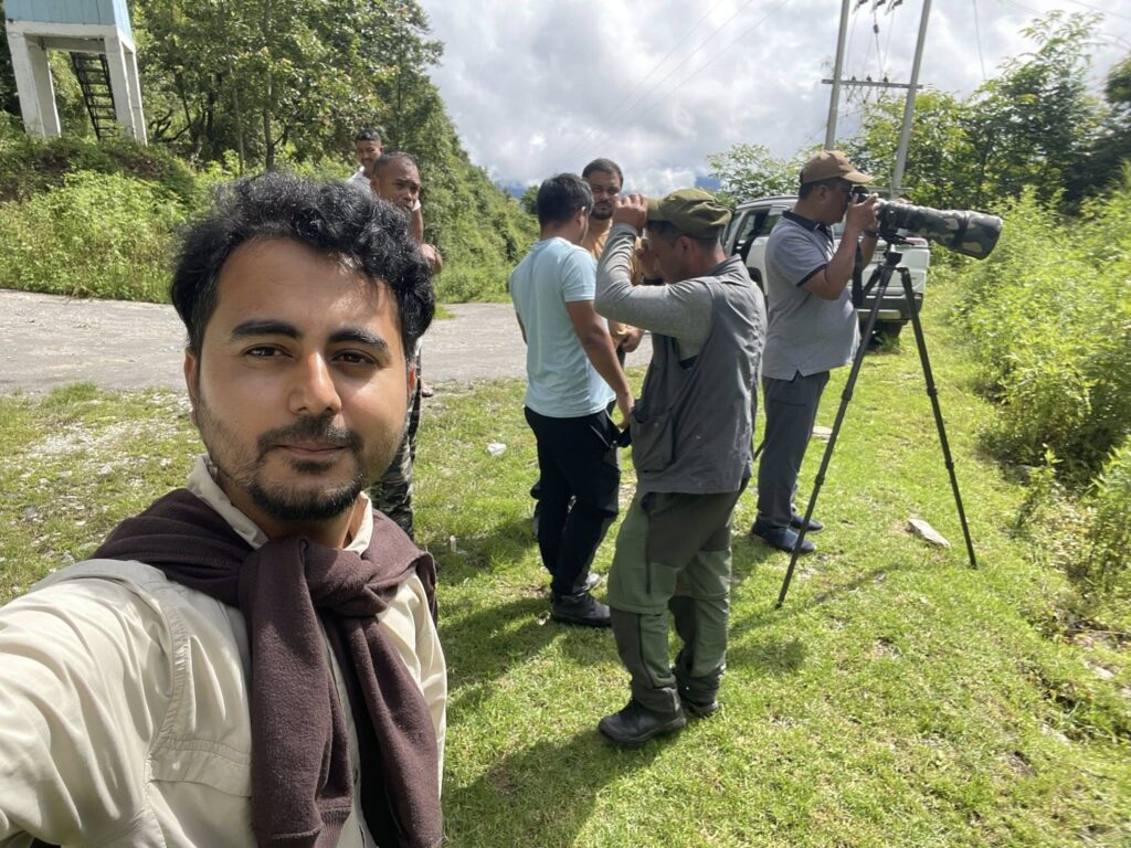 Group of birders with spotting scopes and cameras observing birds along roadside in Arunachal Pradesh India