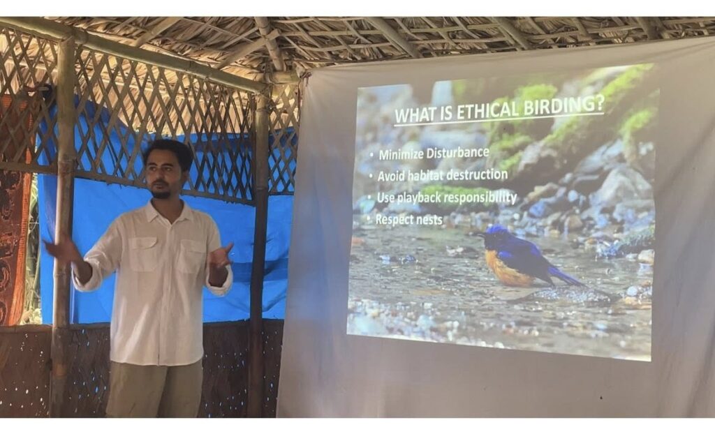 Naturalist guide giving educational presentation on ethical birding practices with projected slides showing conservation principles